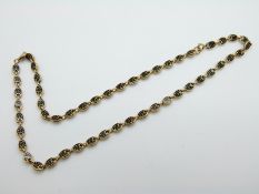 A yellow metal necklace set with black enamel, 17.