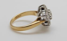 An 18ct gold ring set with seven round brilliant cut diamonds, the centre stone approximately 0.