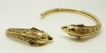 An 18ct gold section of a bangle in the form of a dolphin with ruby eyes, 18.