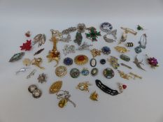 A collection of brooches including 1950s examples, thistle, enamel and swallow examples,