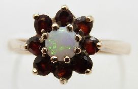 A 9ct gold ring set with an opal surrounded by garnets, size L, 2.