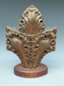 A carved oak fleur-de-lys finial on plinth,