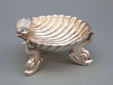 Victorian hallmarked silver shell shaped pedestal salt raised on three dolphins, Birmingham 1892,