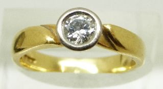 An 18ct gold ring set with a round cut diamond of approximately 0.