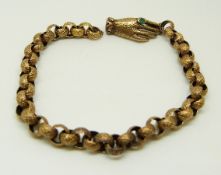 A Victorian bracelet made up of engraved links, the clasp in the form of a hand set with an emerald,