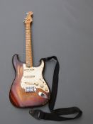 Fender Stratocaster, serial number F204657, with shoulder straps and some spare accessories,