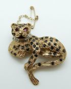 A 9ct gold brooch in the form of a leopard set with sapphires, a diamond collar and ruby eyes,