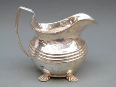 Georgian hallmarked silver cream jug with shell feet and ribbed body, marks rubbed, London 1829,