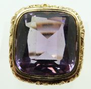 A 9ct gold ring set with a large cushion cut amethyst in an engraved foliate surround, size M, 8.
