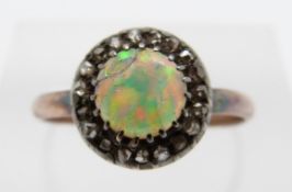 A Victorian ring set with a round cut opal cabochon surrounded by rose cut diamonds, size N, 1.