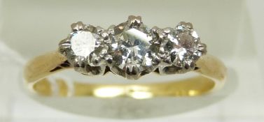 An 18ct gold ring set with three diamonds in a platinum setting,