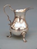 Georgian hallmarked silver cream jug, raised on three feet with scrolling handle, London 1765,