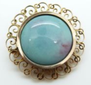 A yellow metal brooch set with a portrait to one side and verso a ceramic cabochon