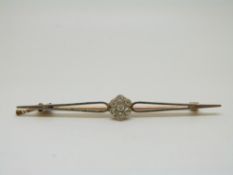 A gold brooch with platinum finish set with diamonds in a cluster