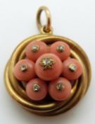 A Victorian pinchbeck knot pendant set with coral and rose cut diamonds verso a glass compartment