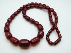 A cherry amber necklace of 51 barrel shaped beads,