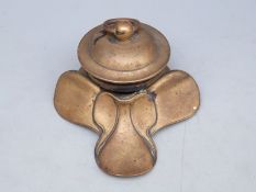 A brass inkwell in the form of a saddle, 9cm tall,