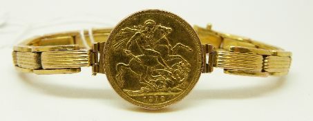 A 1912 gold full sovereign on a yellow metal watch strap,