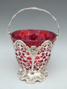 Victorian hallmarked silver and cranberry glass swing handled bowl with pierced and embossed