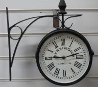 A wall mounted double sided station style quartz clock with Kensington,