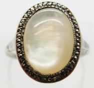 A silver ring set with a mother of pearl cabochon surrounded by marcasite, size T, 3.