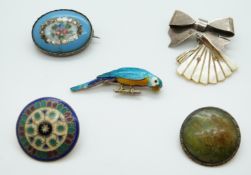 A white metal button set with enamel, an enamel parrot brooch, silver and pottery brooch,