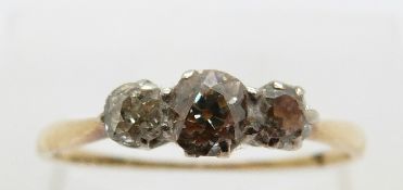 An 18ct gold ring set with three old cut diamonds, the centre diamond approximately 0.