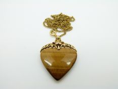 A 9ct gold pendant set with a heart shaped tiger's eye