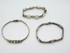 Three silver bracelets set with opals
