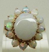 A yellow metal ring set with a cluster of opals, size Q, 4.9g.