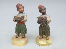 A pair of Austrian cold painted bronze figures of African children bearing caskets of jewels,