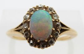An 18ct gold ring set with an opal surrounded by old cut diamonds in a cluster, size P/Q, 6.
