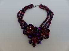 A Butler & Wilson necklace made up of faceted red beads and purple beads with three tiered flowers