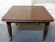 Victorian mahogany dining table with reeded legs raised on ceramic castors,