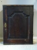 An 18th / 19thC spice cabinet with panelled door opening to reveal cubby holes and drawers,