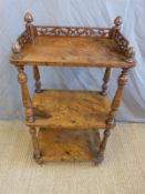 A 19thC walnut three tier whatnot with gallery top,