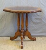 Mahogany and specimen wood octagonal table on three turned supports raised on a shaped trefoil base,