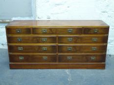A campaign style chest of three over six drawers,