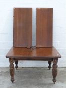 Victorian wind out extending dining table with two extra leaves raised on carved legs,