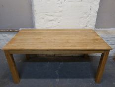A contemporary light oak dining table,