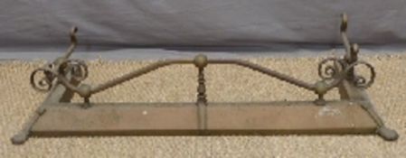 An ornate brass fire fender raised on lion pad feet,