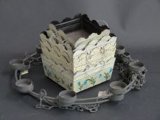 A pair of wrought iron hanging candelabra to take eight candles each and a quantity of plant