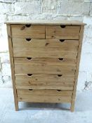 A pine chest of two over four drawers with finger apertures for opening,