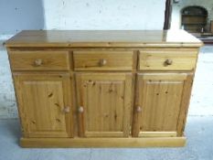 Pine sideboard with three drawers over three cupboards,
