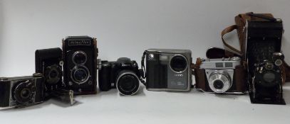 A quantity of cameras to including Fuji Finepix S5600 and S304, Halma Flex TLR, Kodak Retinette 1A,