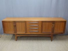 Retro G Plan sideboard with twin cupboards flanking four drawers, shaped legs and supports,