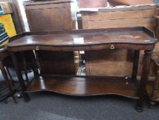A 19thC mahogany serpentine fronted side table with two drawers and shelf below raided on tapering