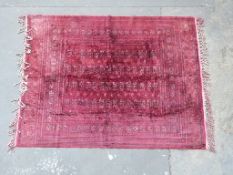 Turkoman fine wool / silk rug with geometric design on a wine ground,