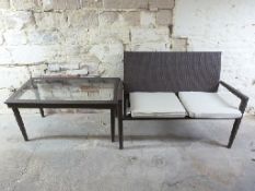 A contemporary garden or conservatory two seat bench sofa and coffee table with glass top,