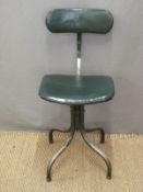 An industrial office swivel chair with four legs and green upholstery.
